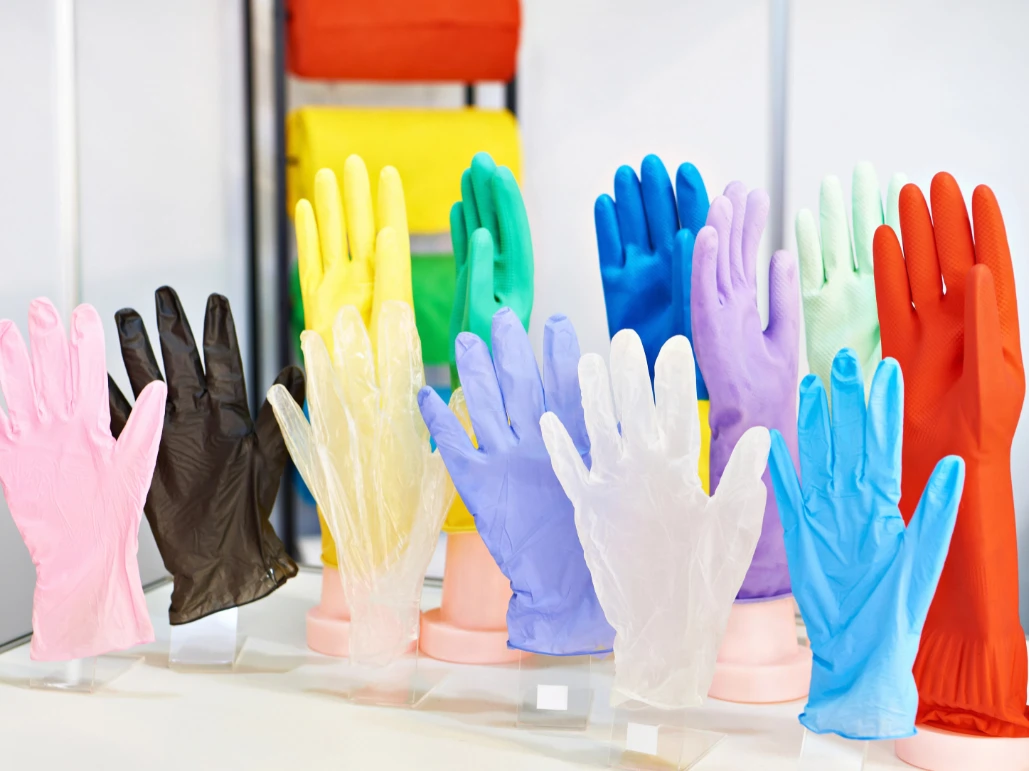 Close-up of a black disposable glove on a person's hand outdoors.